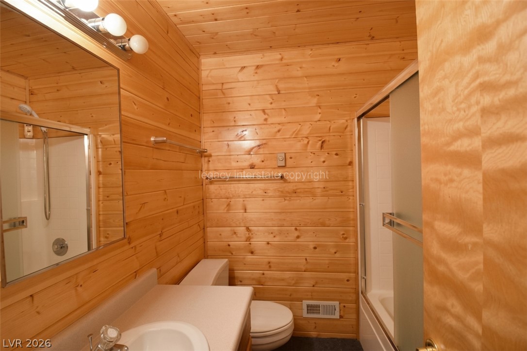 1129 East Ponderosa Road Hatch, UT 84735 - Photo 28 of 47 Warm wood paneling wraps this cozy bathroom featuring a classic vanity and glass-enclosed shower.
