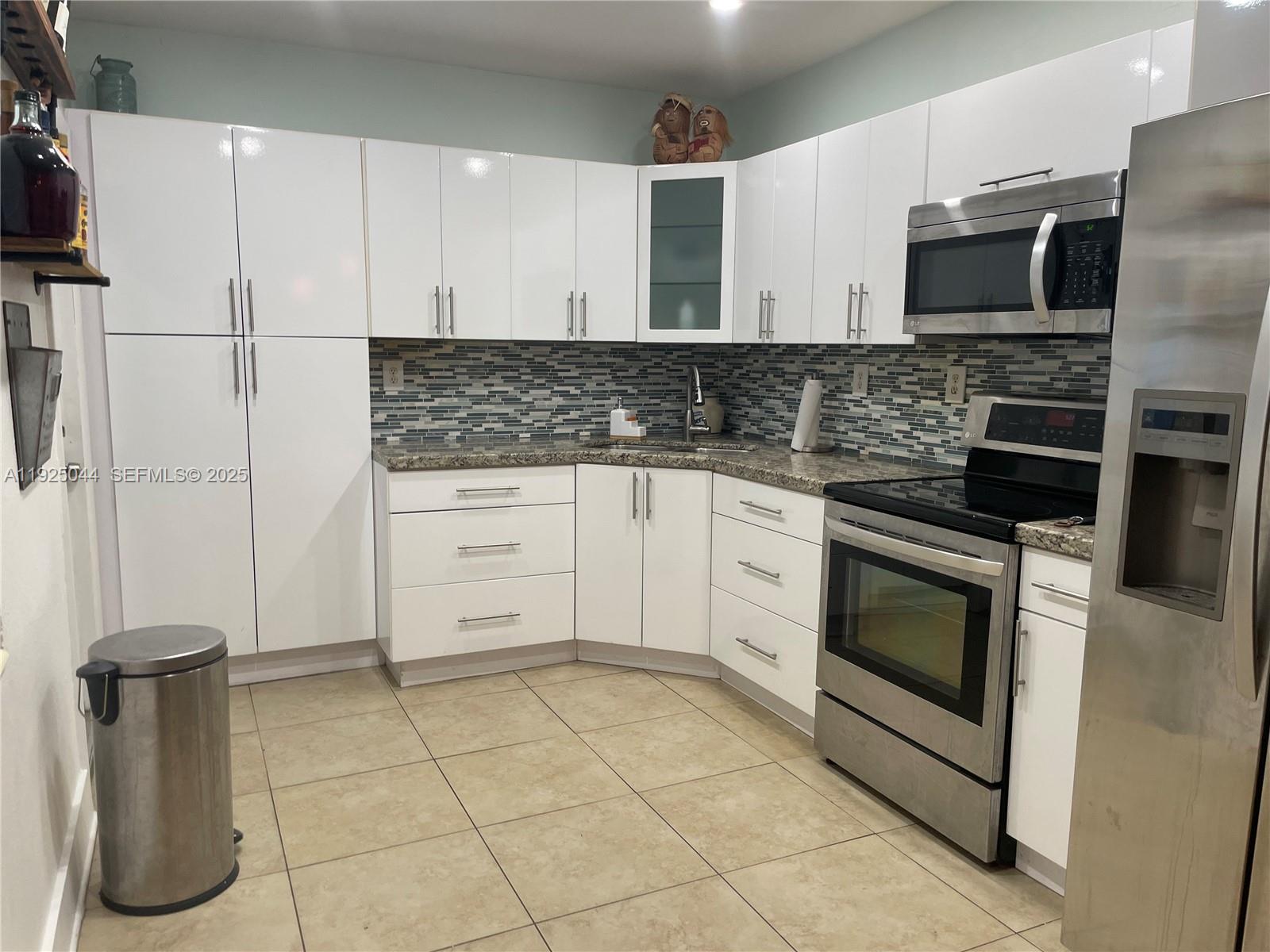 705 East 9th Court Hialeah, FL 33010 - Photo 28 of 36 a kitchen with granite countertop cabinets and steel stainless steel appliances
