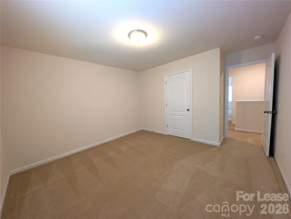 an empty room with closet and mirror