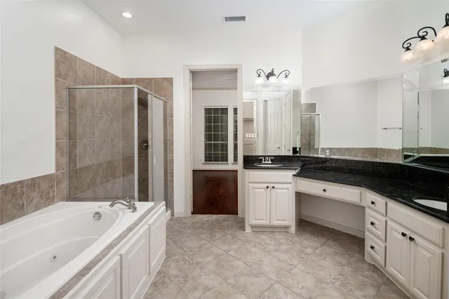 a large bathroom with a bathtub sink and mirror
