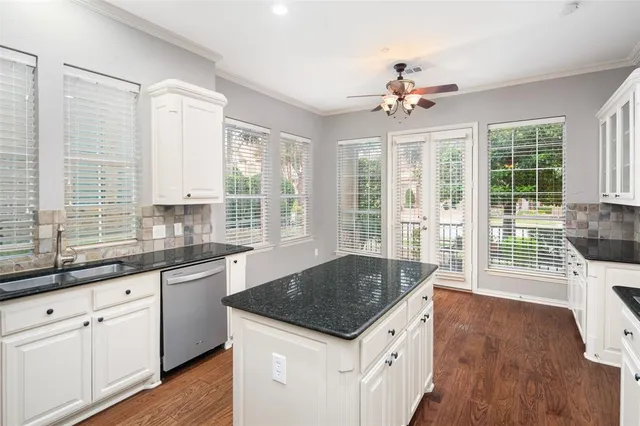 a kitchen with a stove a sink and dishwasher with wooden floor