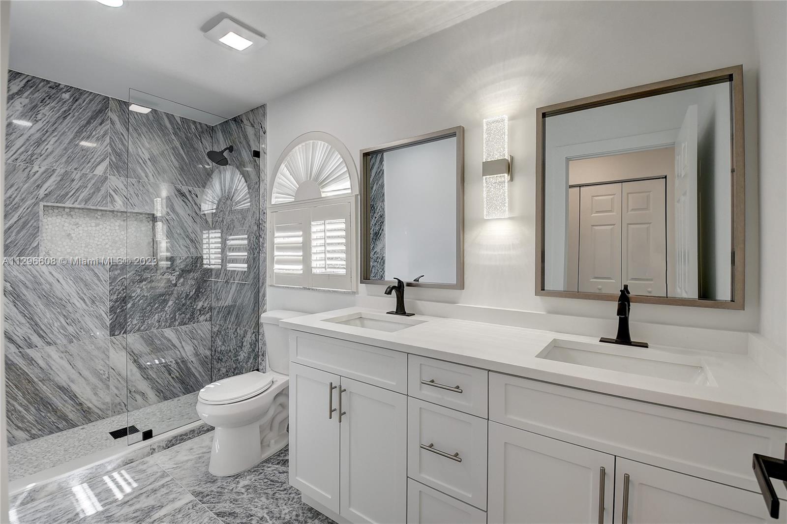 2875 Northwest 28th Street Boca Raton, FL 33434 - Photo 28 of 32 a bathroom with a toilet a sink and mirror