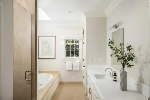 a spacious bathroom with a tub sink and mirror