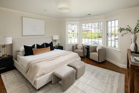 a bedroom with bed and a large window