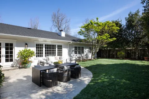 a view of a house with backyard sitting area and garden