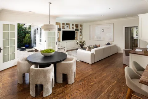 a living room with furniture a flat screen tv and a large window