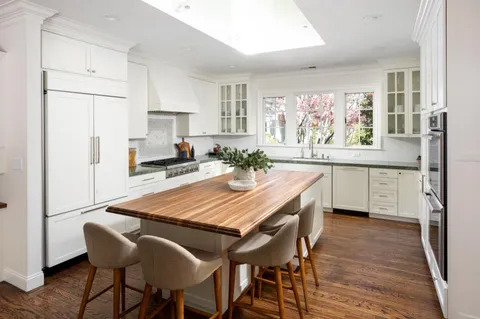 a dining room filled chandelier and wooden floor