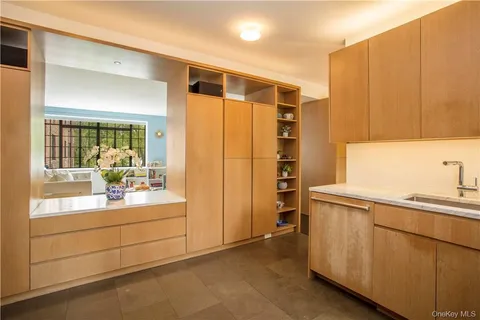 a kitchen with white cabinets and sink