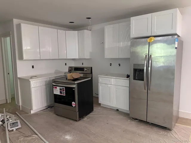 a kitchen with stainless steel appliances granite countertop a refrigerator a sink and a stove