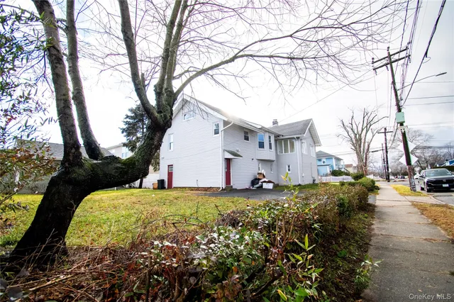 a view of a house with backyard and trees