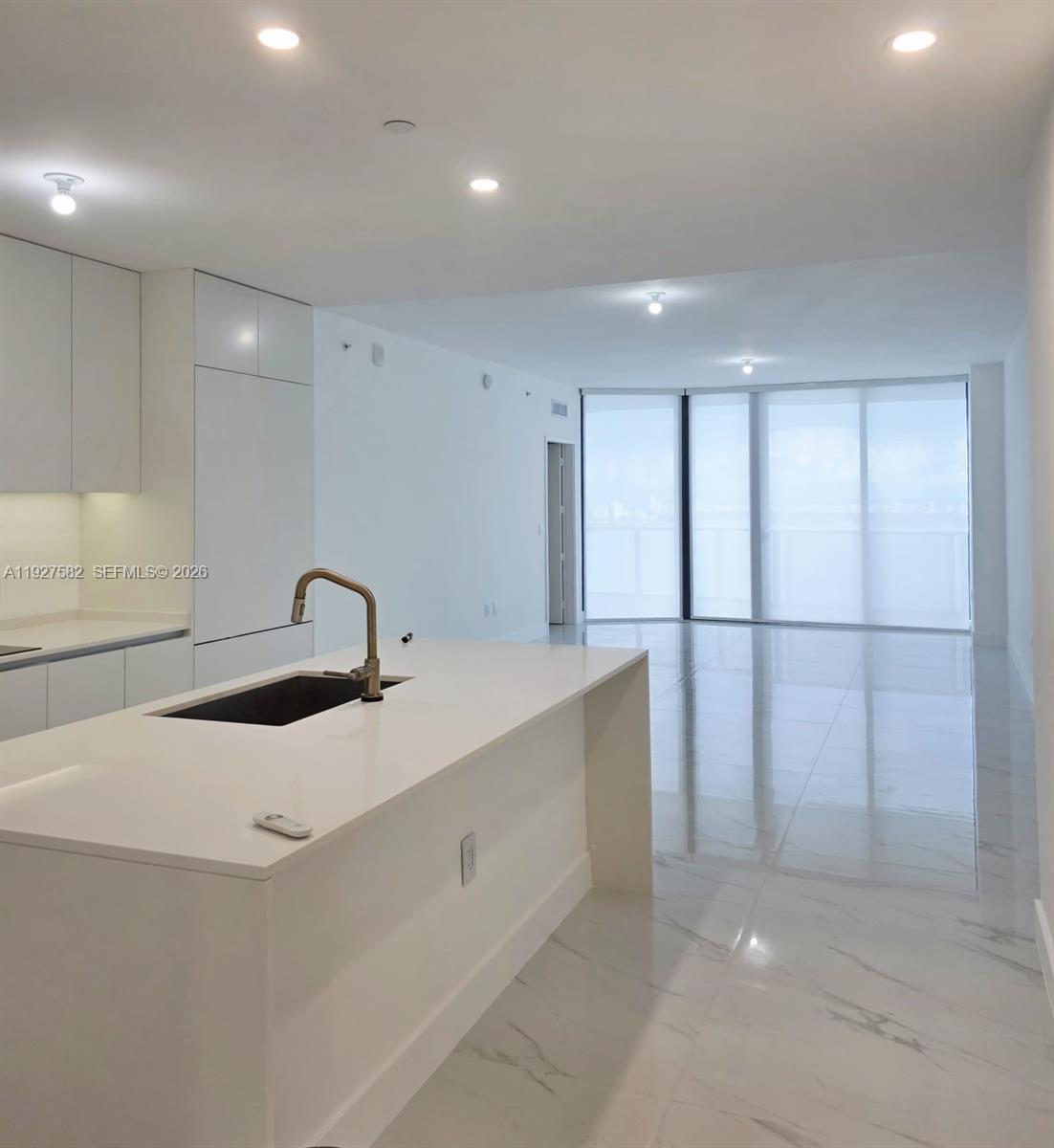 700 Northeast 24th Street, Unit 3803 Miami, FL 33137 - Photo 15 of 22 a kitchen with granite countertop white cabinets and sink