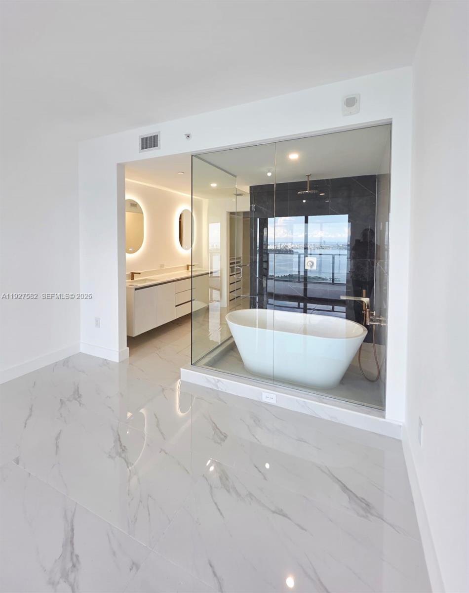 700 Northeast 24th Street, Unit 3803 Miami, FL 33137 - Photo 9 of 22 a view of a bathroom with a tub and mirror