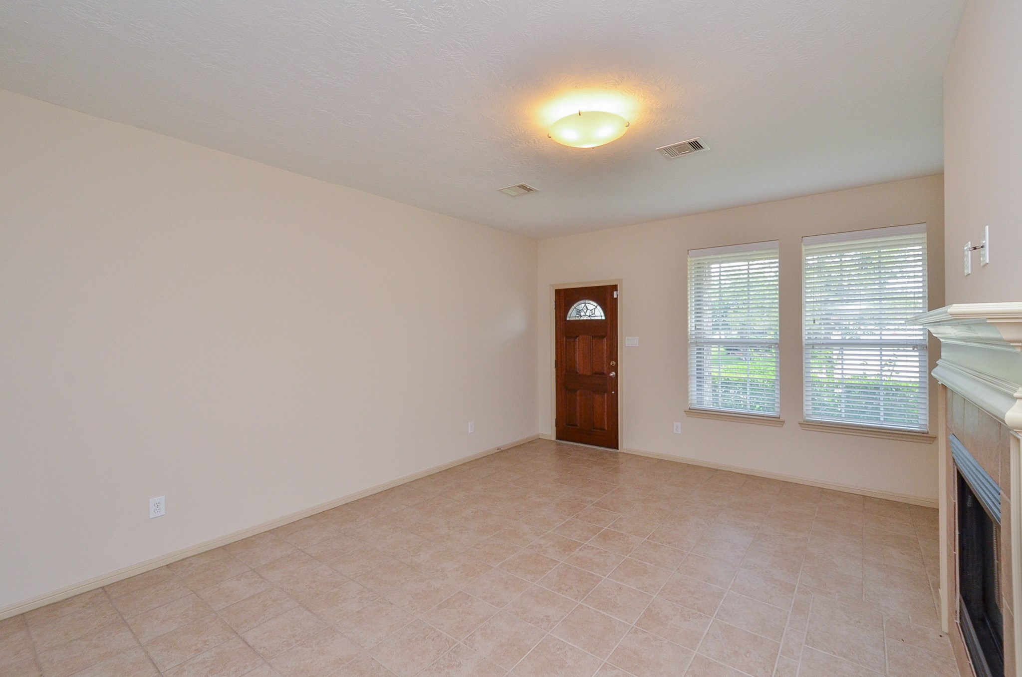 25135 Ginger Ranch Drive Katy, TX 77494 - Photo 5 of 32 This open living area offers tile flooring, neutral tones, and natural light from multiple windows, creating a flexible space for everyday living.