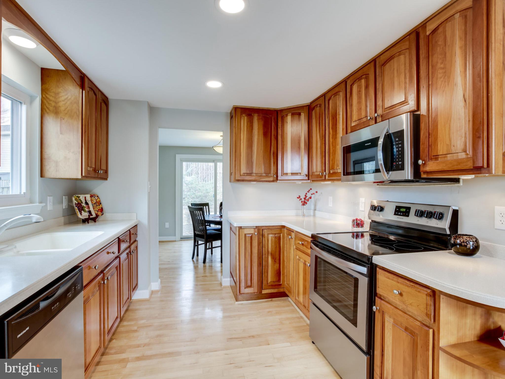 6502 Shipyard Place Falls Church, VA 22043 - Photo 2 of 30 a kitchen with stainless steel appliances granite countertop a stove a sink dishwasher and a microwave oven with wooden cabinets