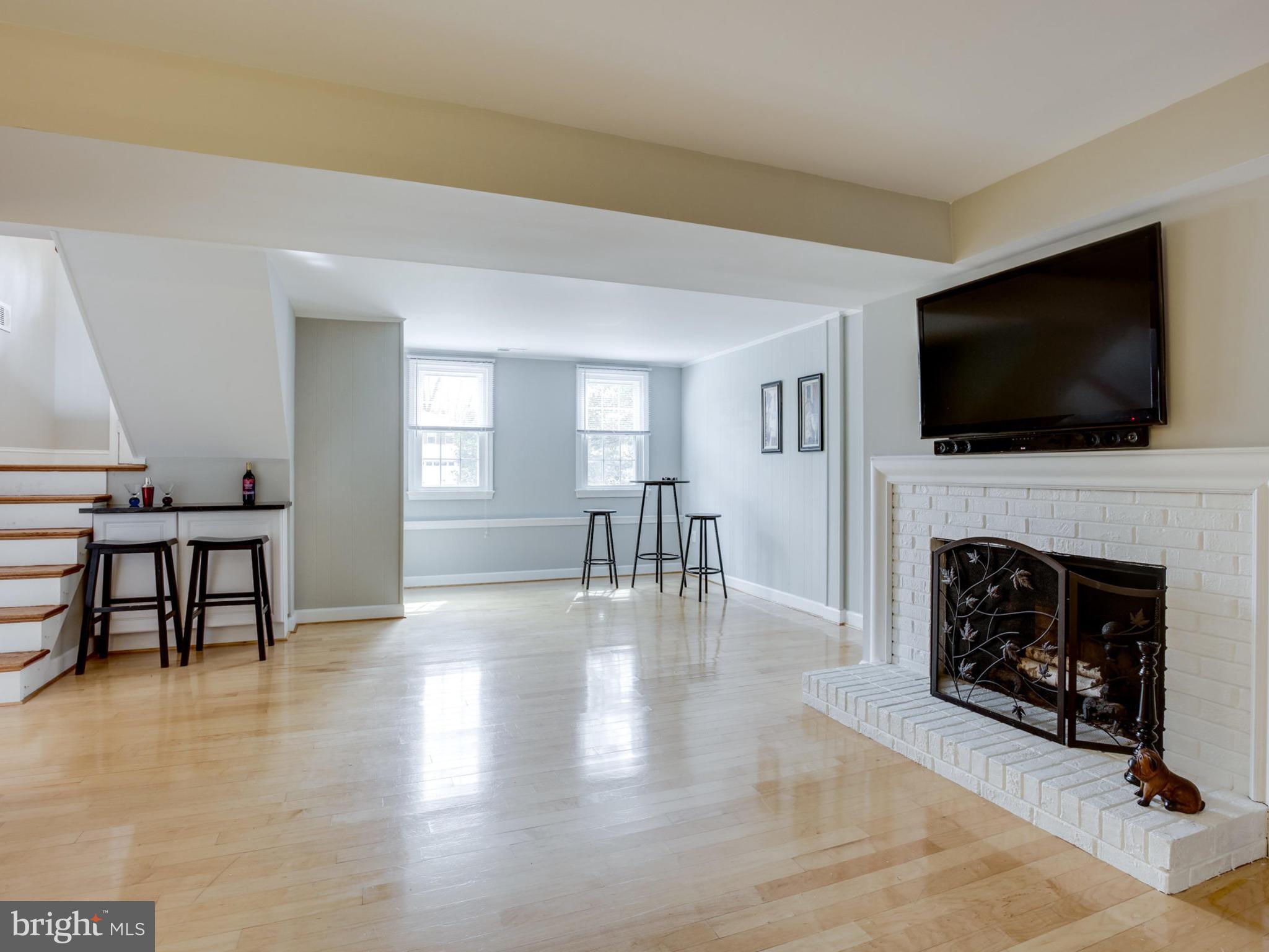 6502 Shipyard Place Falls Church, VA 22043 - Photo 22 of 30 a living room with furniture a fireplace and a flat screen tv