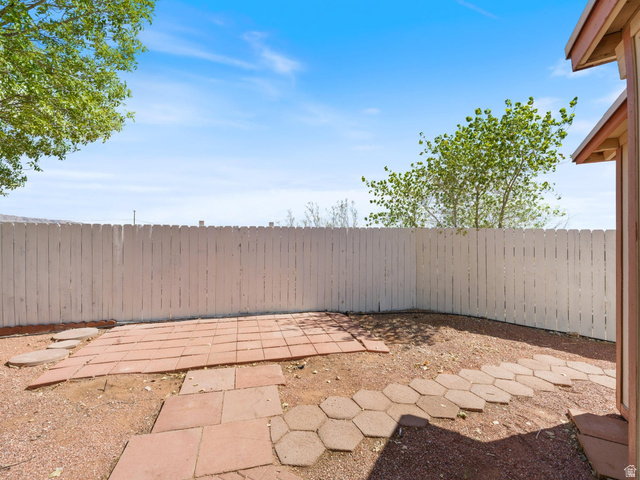 3941 West 40 North Hurricane, UT 84737 - Photo 46 of 55 Enclosed backyard featuring a white picket fence, a red paver patio, and an irregular stone pathway