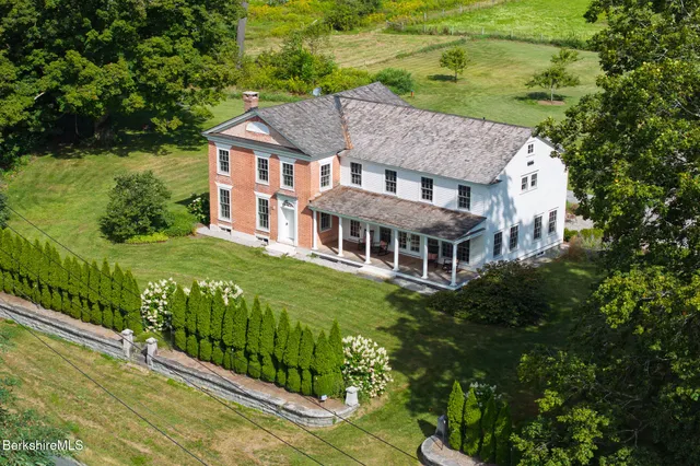 a aerial view of a house next to a big yard and large trees