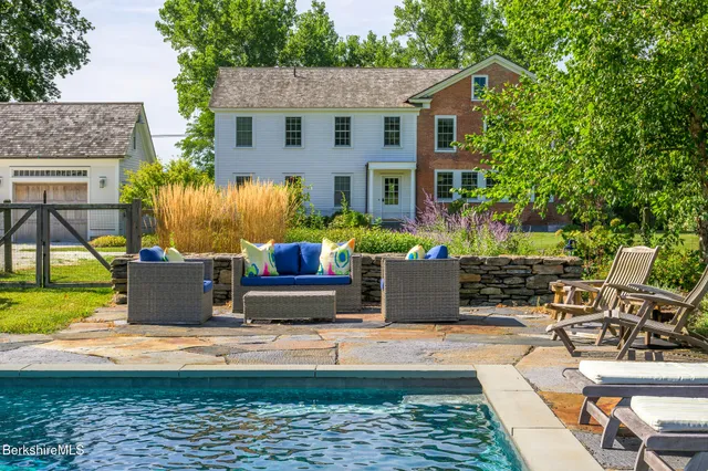a view of a house with backyard water fountain and sitting area