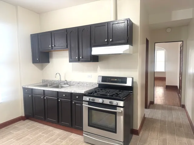 a kitchen with stainless steel appliances a stove a sink and a microwave