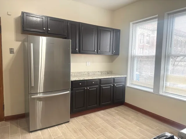 a kitchen with granite countertop stainless steel appliances a refrigerator and a sink