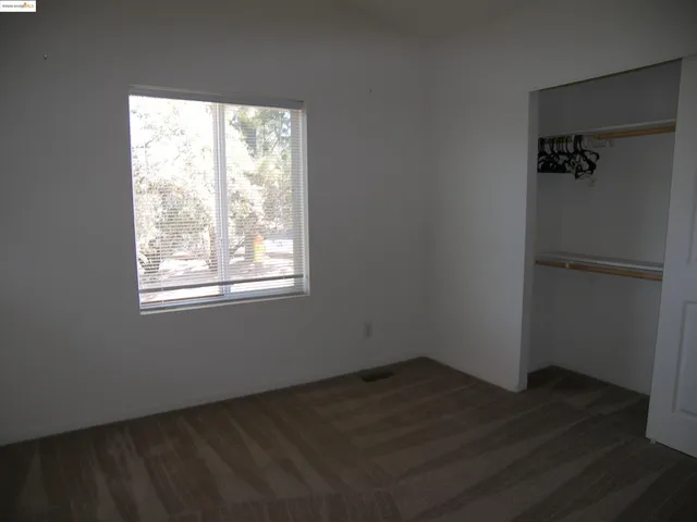 an empty room with wooden floor and a window