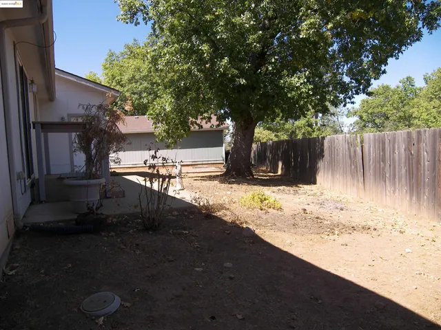 a view of a yard with wooden fence