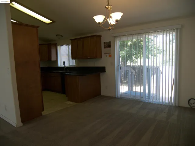 a view of kitchen with granite countertop cabinets and fireplace