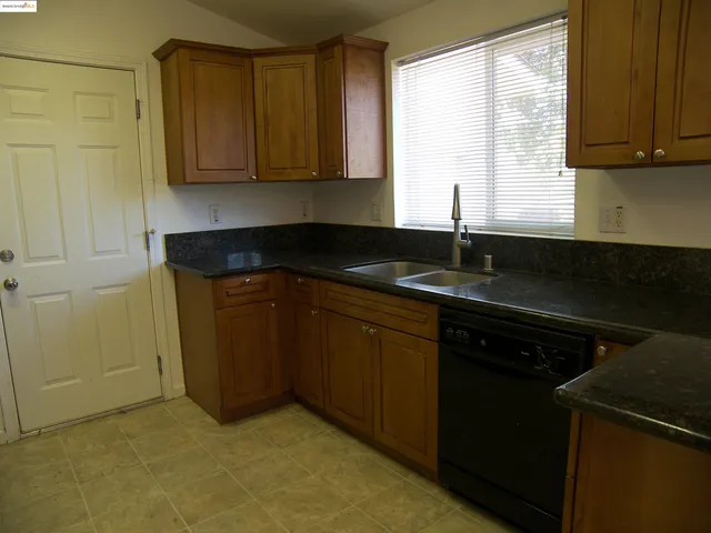 a kitchen with granite countertop cabinets sink and window