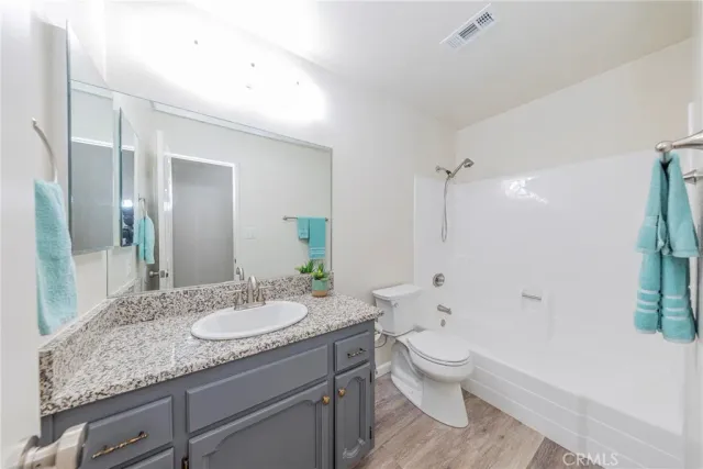 a bathroom with a granite countertop sink toilet a large mirror and shower