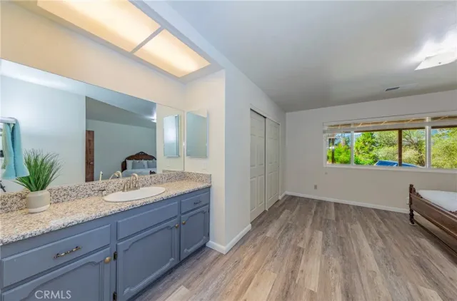 a en suite bathroom with a granite countertop sink and a large mirror
