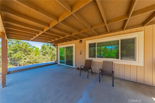 a view of a patio with table and chairs and floor to ceiling window