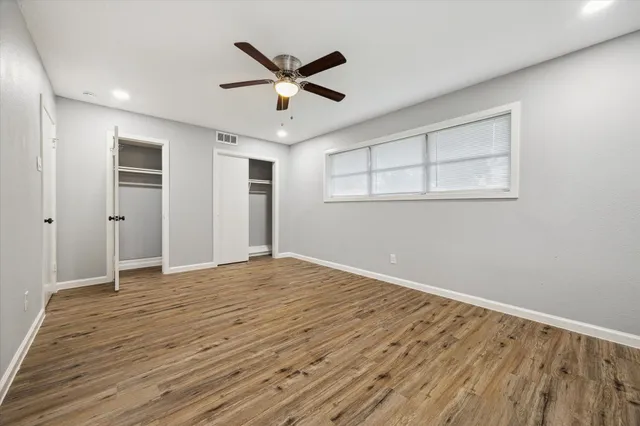 a view of empty room with wooden floor and window