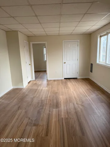 a view of a room with wooden floor and window