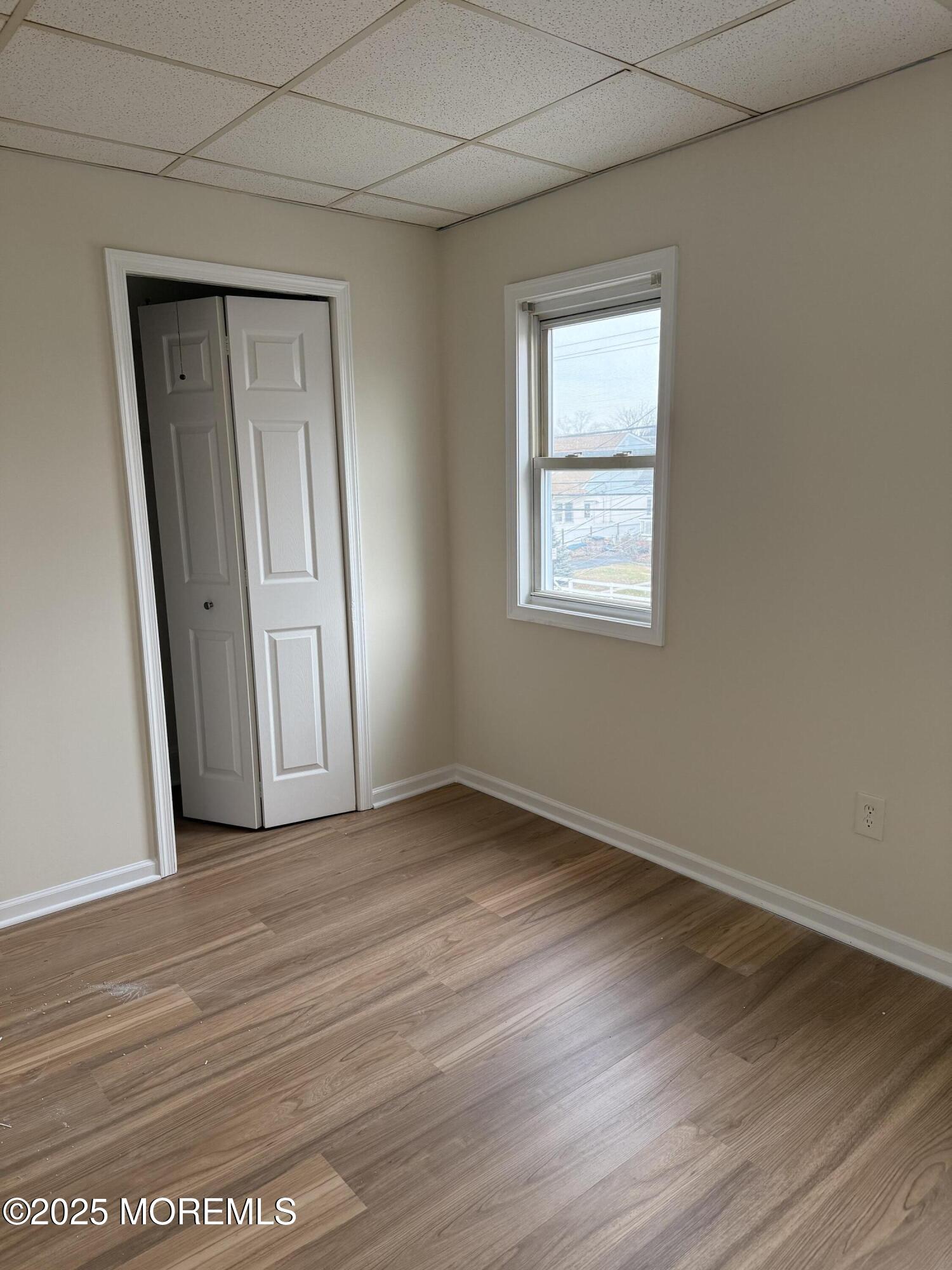 257 Carr Avenue, Unit B Keansburg, NJ 07734 - Photo 9 of 11 an empty room with wooden floor and window