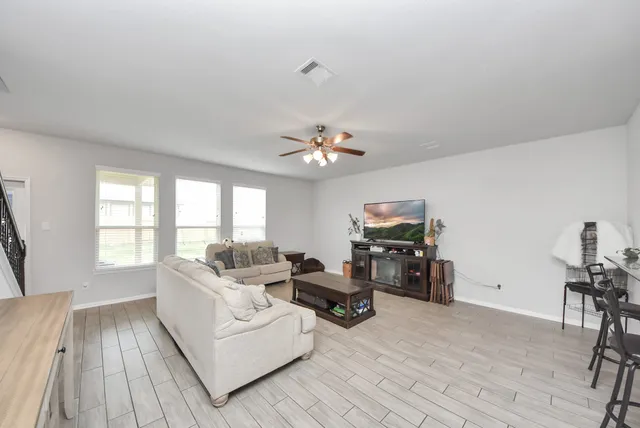 a living room with furniture and wooden floor