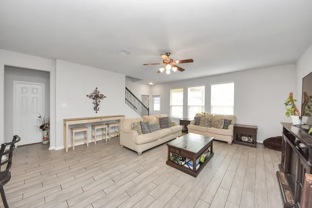 a living room with furniture and a wooden floor