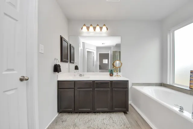 a spacious bathroom with a sink a large mirror and a bathtub