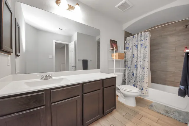 a bathroom with a double vanity sink toilet and shower
