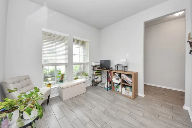a living room with furniture and a dining table with wooden floor