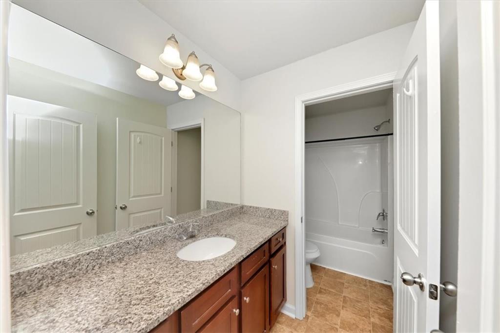 541 Tulip Lane McDonough, GA 30252 - Photo 18 of 32 a bathroom with a granite countertop sink and a mirror