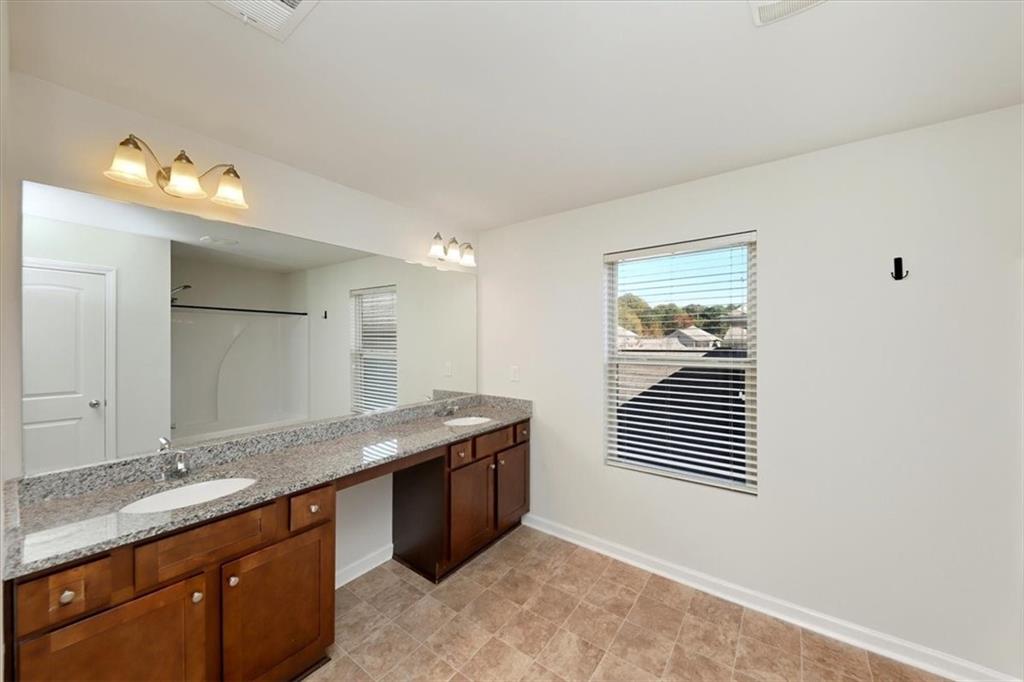 541 Tulip Lane McDonough, GA 30252 - Photo 25 of 32 a bathroom with a granite countertop sink a mirror and a