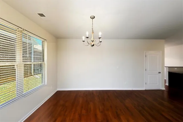 a view of a room with wooden floor and a chandelier