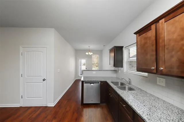 a kitchen with granite countertop cabinets stainless steel appliances a sink and a large window