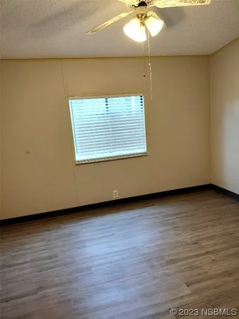 a view of a room with wooden floor and white walls