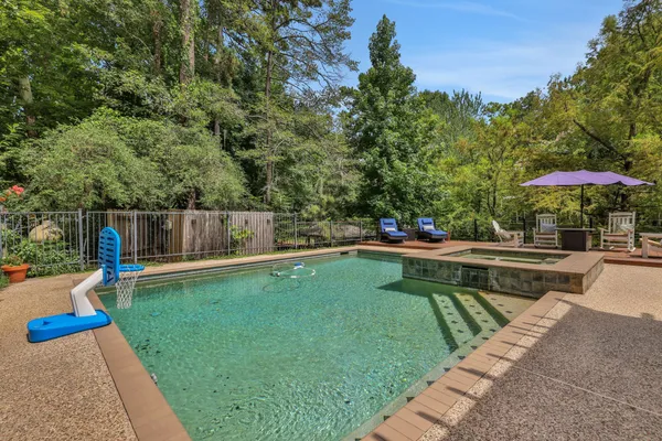 a view of a swimming pool with a patio and a yard