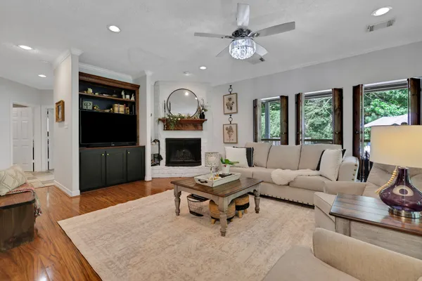 a living room with furniture a fireplace and a flat screen tv
