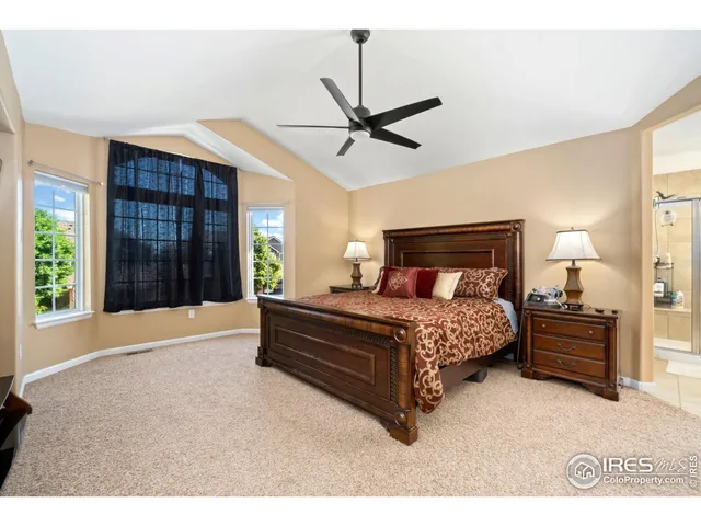 a bedroom with a bed large window with ceiling fan