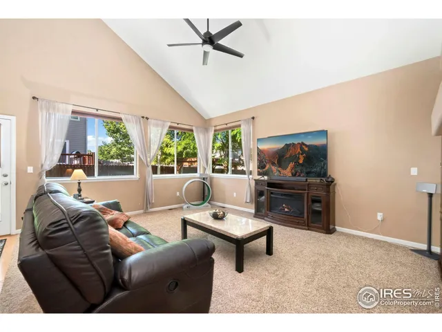 a living room with furniture a window and a flat screen tv
