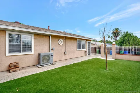 a backyard of a house with table and chairs