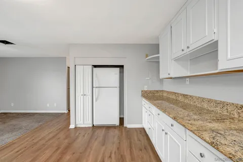 a kitchen with granite countertop a sink and cabinets